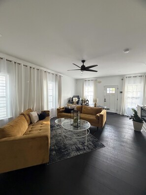 A modern living room with a sofa, coffee table, and a ceiling fan. - Lovely 2-bedroom house in vibrant Downtown Atlanta (Atlanta)