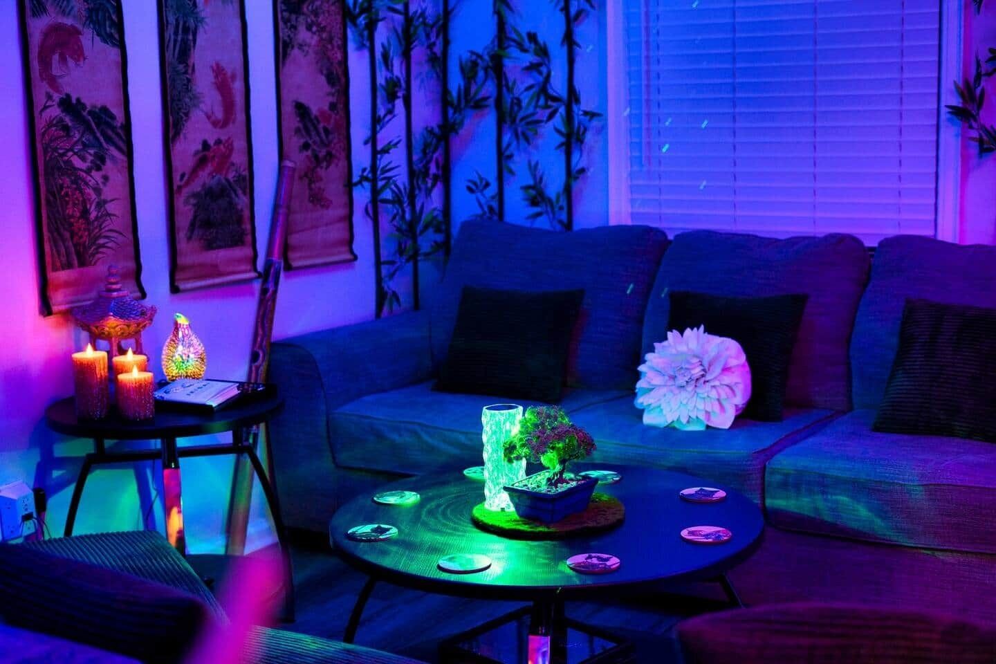 A room with a sofa, a small table with decorative items, and wall art.