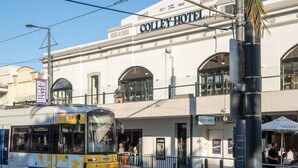 En byggnad med en skylt där det står ”Colley Hotel”, och en spårvagn som passerar förbi.