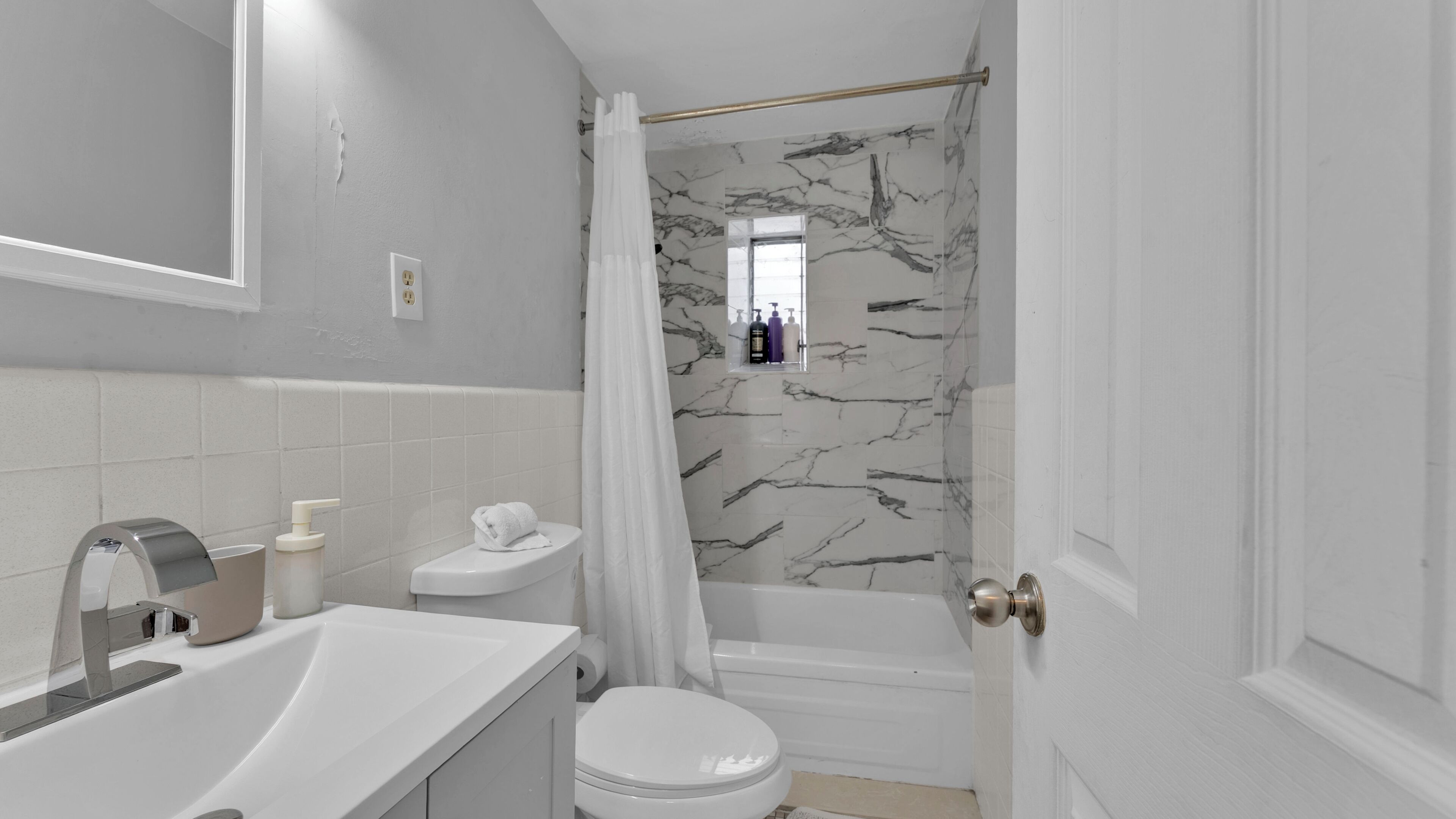 A bathroom with a toilet, sink, and bathtub.