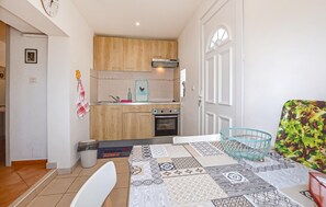 A compact kitchen with wooden cabinets, a built-in oven, and a sink. - 1 bedroom awesome apartment in Bastia (Bastia)