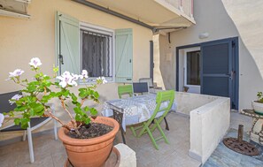 A small outdoor patio with a table and chairs, a potted plant, and a door. - 1 bedroom awesome apartment in Bastia (Bastia)