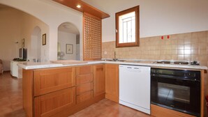 Eine Küche mit Holzausstattung, einem Geschirrspüler und einem Backofen.