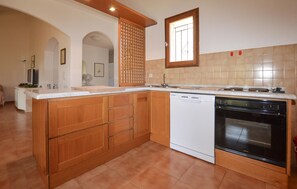 Eine Küche mit Holzausstattung, einem Geschirrspüler und einem Backofen.