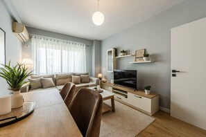 A modern living room with a sofa, coffee table, TV, and decorative items. - Calm Cozy Home 1BR in Tirana (Tirana)