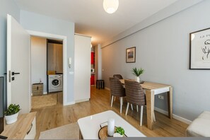 A modern apartment with a dining area, a kitchen, and a laundry room. - Calm Cozy Home 1BR in Tirana (Tirana)