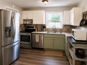A modern kitchen with stainless steel appliances, a built-in oven, a microwave, and a sink. - 3BR Largo Home Near Indian Rocks & Madeira Beach (Largo)