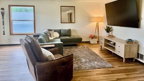 Een woonkamer met een bank, een salontafel, een televisie en een lamp.