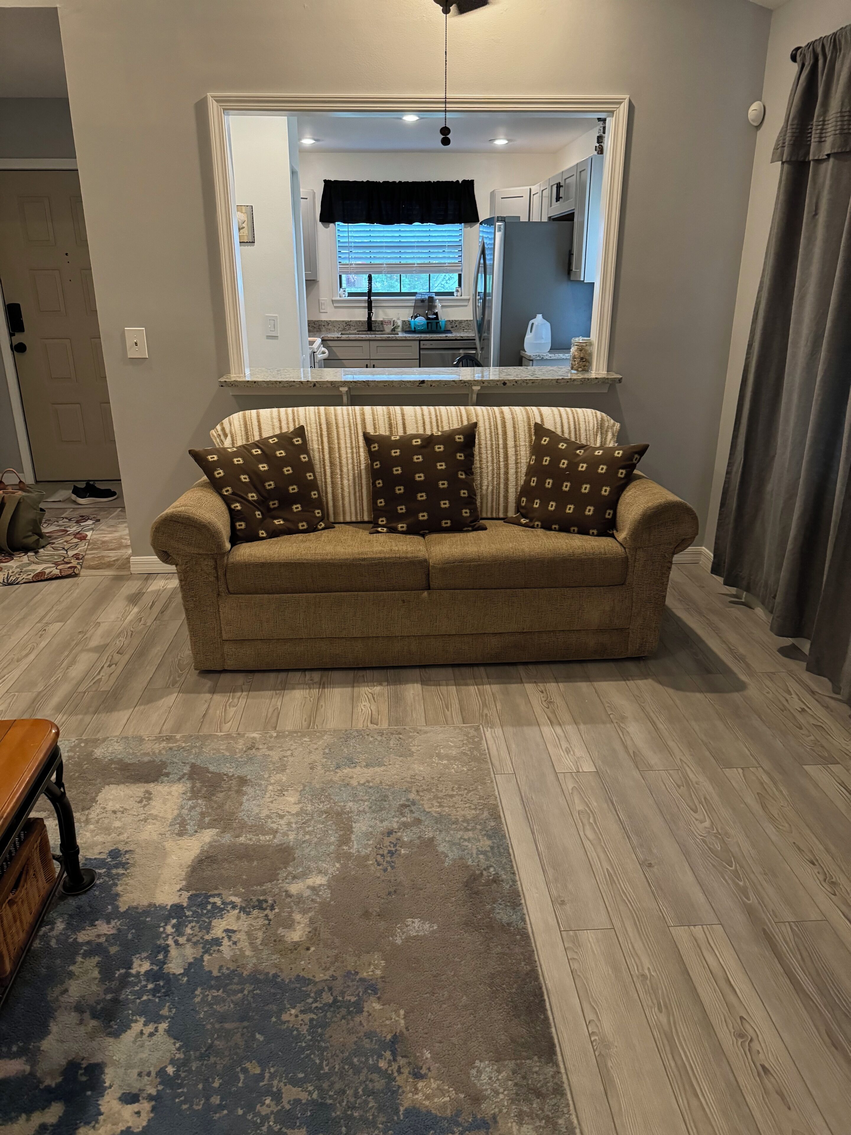 Uma sala de estar com sofá, mesa de centro e tapete.