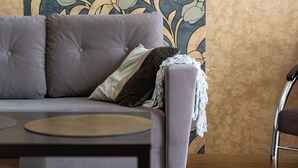 Ein graues Sofa vor einer Wand mit Muster.