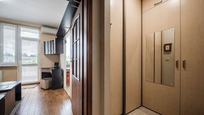 Eine moderne Küche mit Holzboden, einem Einbauofen und einem Fenster mit Jalousien.