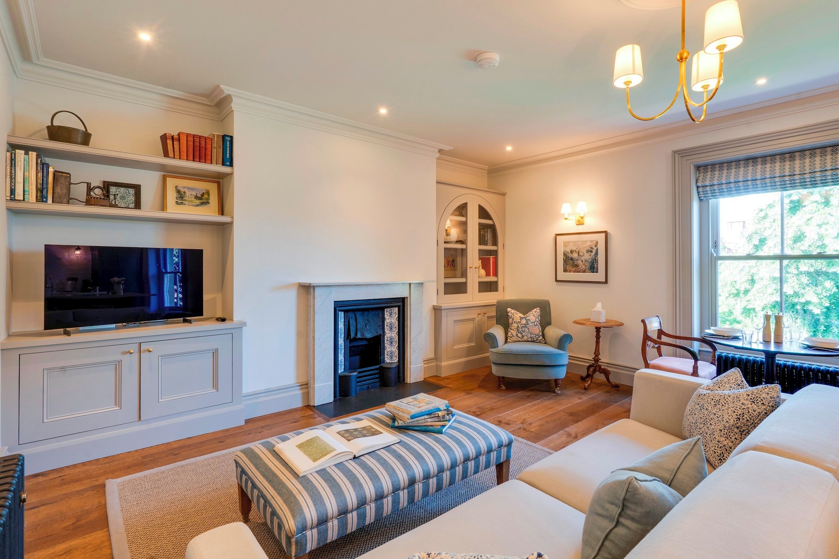 A living room with a fireplace, television, and bookshelves.