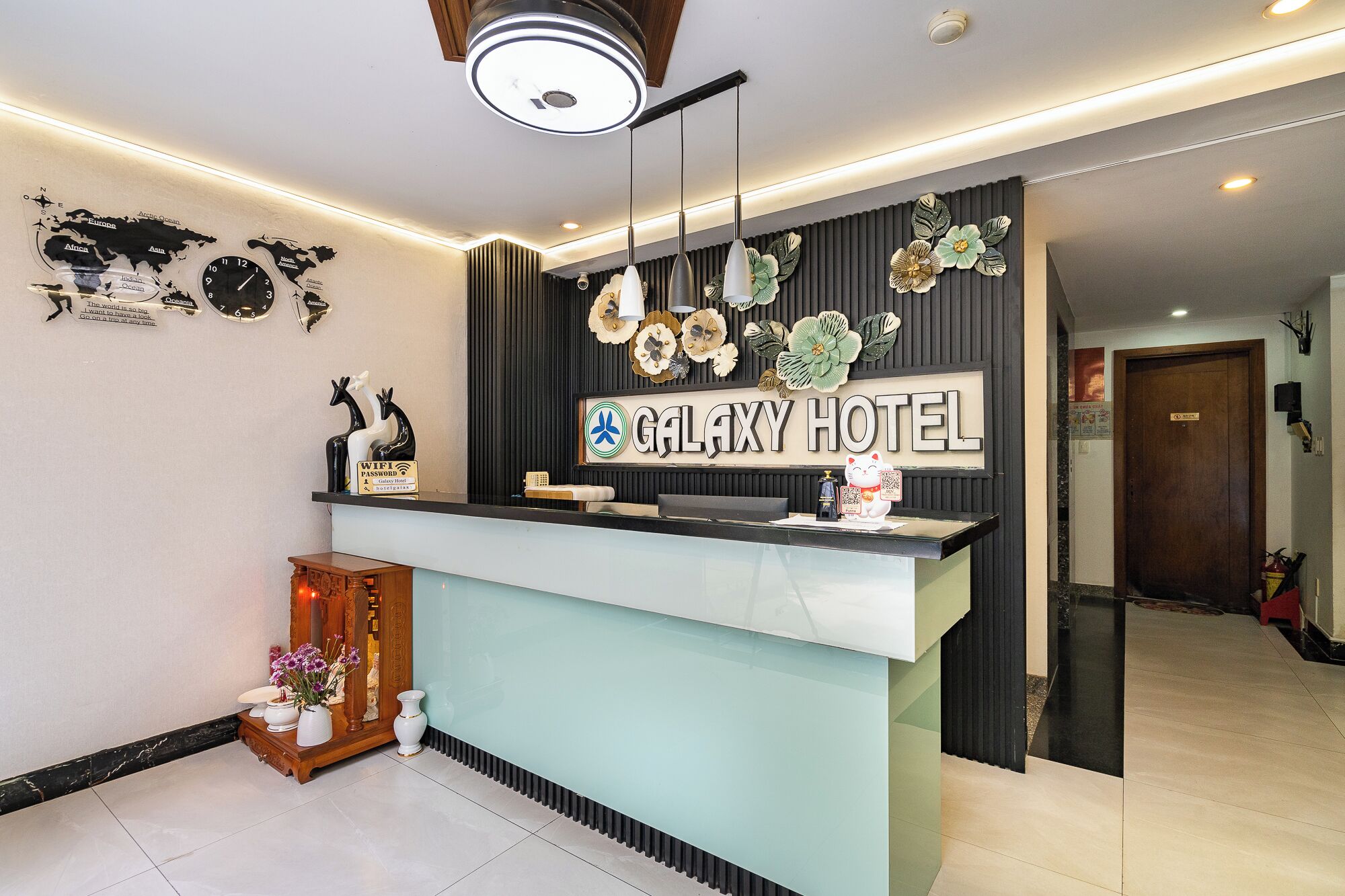 Una recepción de hotel de diseño moderno, un mapa del mundo y un letrero del Hotel Galaxy.