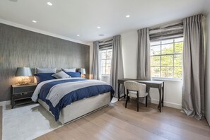 Ein Schlafzimmer mit Bett, Nachttischen, Schreibtisch und Stuhl.
