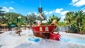 Un espace de jeux sur le thème des pirates, avec des toboggans et une petite structure en forme de bateau.