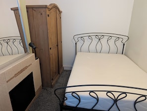 Une chambre à coucher avec un lit, une armoire et un radiateur.