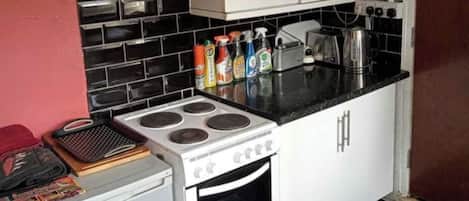 A compact kitchen with a stove, oven, and various kitchen appliances.