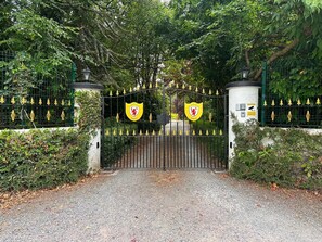 Una entrada protegida per una tanca, amb un camí empedrat que hi passa.
