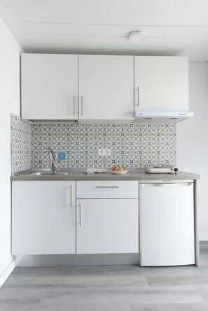 A modern kitchen with white cabinets, a patterned backsplash, and a built-in dishwasher. - Tiny House in the Country (San Bartolome de Tirajana)