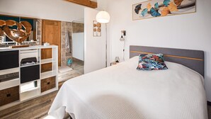 Ein Schlafzimmer mit Bett, Nachttisch, Kommode und Spiegel.