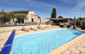 A swimming pool with lounge chairs, a pergola, and a tall tree in the background. - Lovely home in Valréas (Valréas)