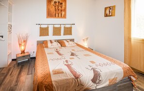 A bedroom with a bed, bedside tables, a wall-mounted shelf, and artwork. - Lovely home in Valréas (Valréas)