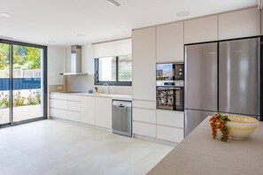 Eine moderne Küche mit Geschirrspüler, Backofen und einem Edelstahl-Kühlschrank.