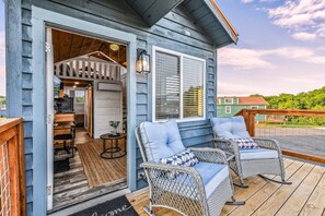 A wooden deck with wicker chairs and a small table. - Tiny Home Village Near Dollywood | Sleeps 60+ (Sevierville)