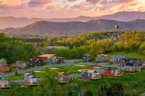 A residential area with houses, a water tower, and mountains in the background. - Tiny Home Village Near Dollywood | Sleeps 60+ (Sevierville)