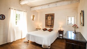 A bedroom with a large bed, two bedside tables, a dresser, a window with curtains, a wall tapestry, and a framed picture. - Awesome home in Labeaume with WiFi (Labeaume)