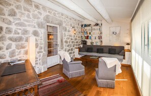 Ein gemütliches Wohnzimmer mit Steinwand, Bücherregal, Sofa und Couchtisch.