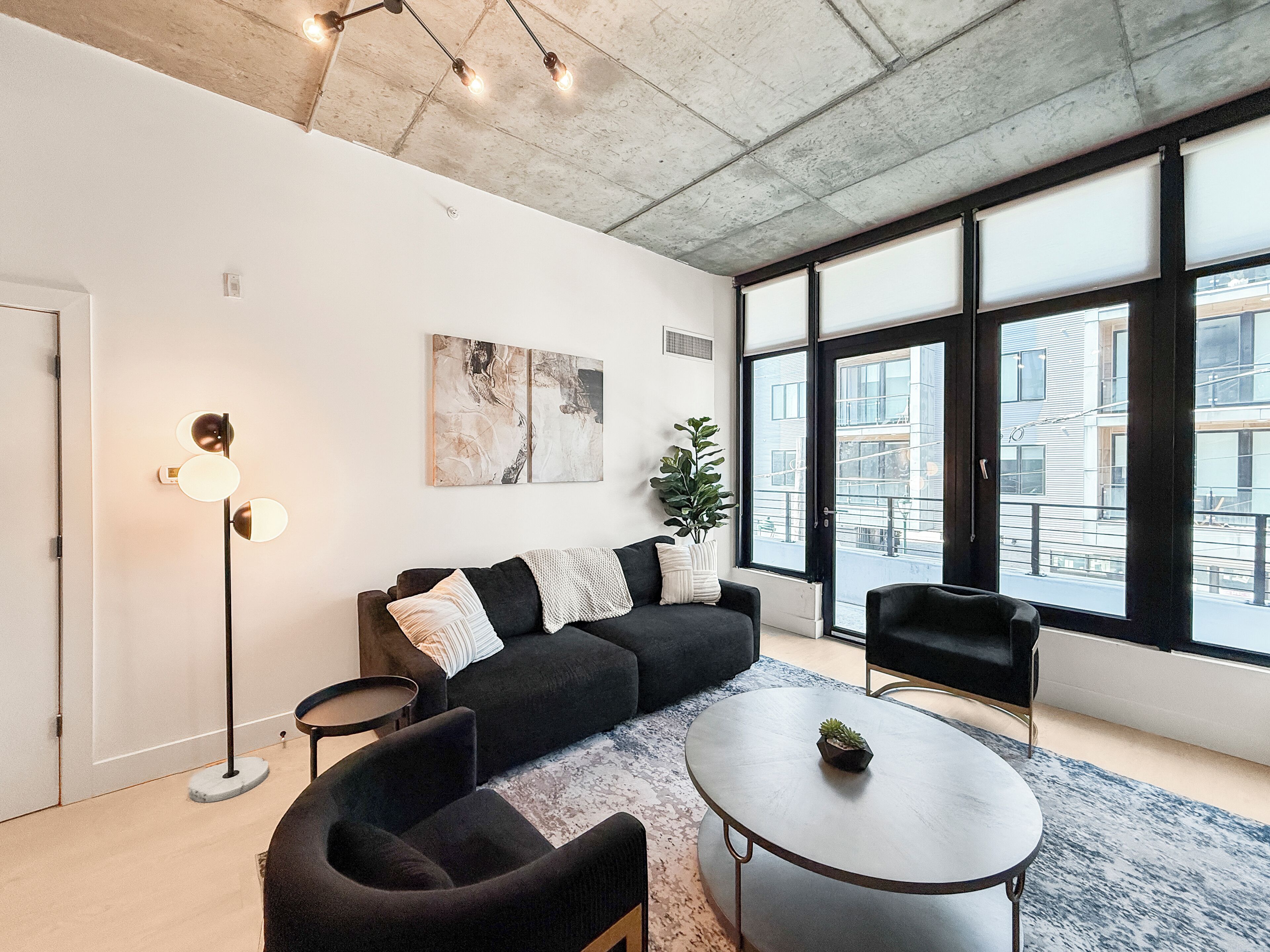 A modern living room with a sectional sofa, a round coffee table, and a floor lamp.