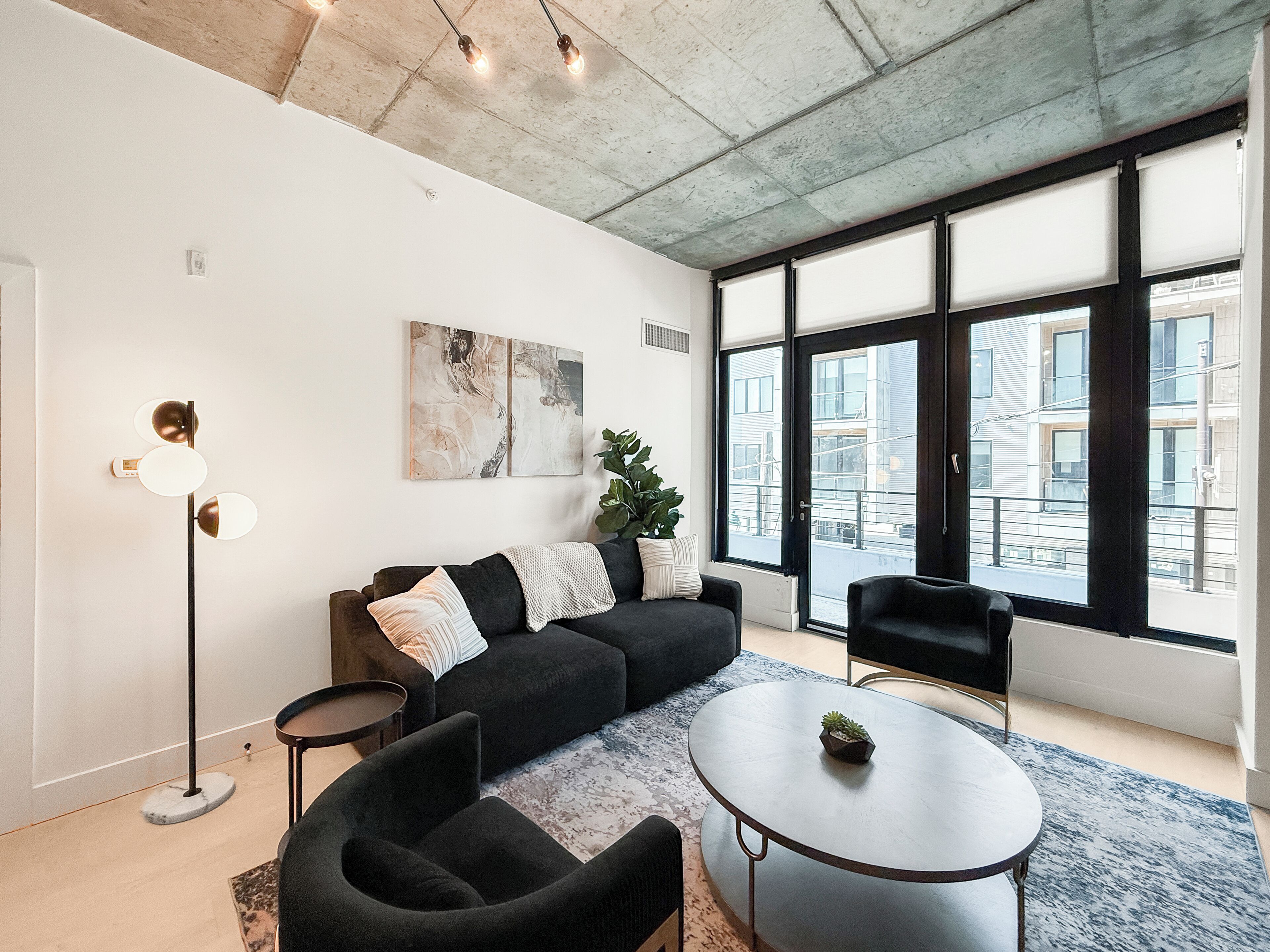Una sala moderna con un sofá modular, una mesita redonda y una lámpara de pie.