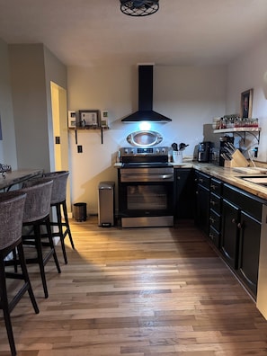Una cocina moderna con una isla central, horno integrado y electrodomésticos de acero inoxidable.