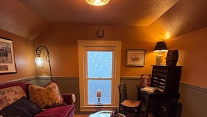 Una habitación acogedora con un sofá rojo, una mesa de centro estampada y una ventana con vistas.