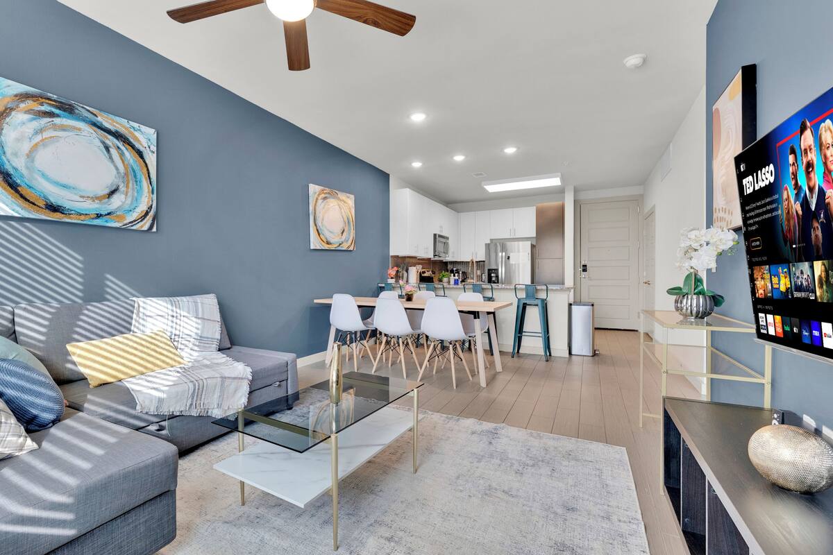 A modern living room with a sofa, coffee table, and artwork on the wall.