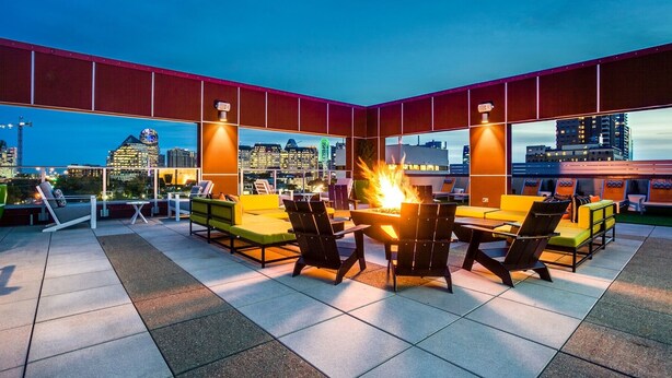 An outdoor seating area with a fire feature and city views. - Apartmint at Bell Katy Trail Dallas (Dallas)