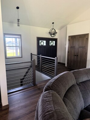 A staircase with metal railings leading to a dark wooden door with frosted glass windows. - Modern New Ranch Retreat for EAA Visitors with Hot Tub (Omro)