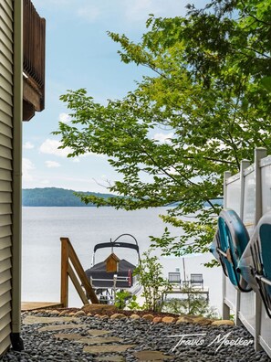 Ein Bootssteg am See mit Grill, einem Kajak und einem Boot.