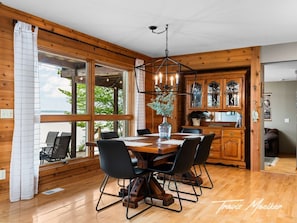 Ein Holzinterieur mit Esstisch, Stühlen und einer Chandelier.