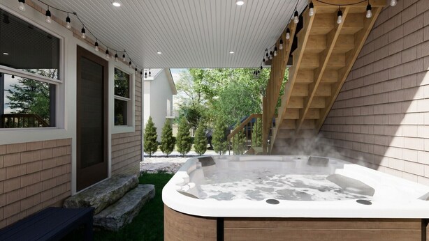 Ein Whirlpool in einem überdachten Außenbereich mit einer Holzterrasse und Blick auf Bäume und ein Haus.