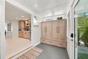 A modern kitchen with wooden cabinets, a built-in oven, and a large window. - Crystal Lake East End Retreat with Dock, Hot Tub & Sunset Views (Beulah)