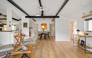 Ein geräumiger Wohnbereich mit Esstisch, Stühlen, einer Couch und einem Fernseher-Schrank.