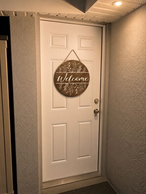 A white door with a 'Welcome' sign.