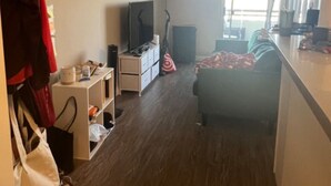 Una camera d'albergo con un letto, una televisione, una scrivania, una sedia e un armadio.