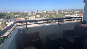 Un balcone con vista su una zona residenziale, un tavolo rotondo e due sedie.