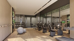 Une salle de sport moderne équipée de matériel d’exercice, dotée d’un comptoir d’accueil et d’un grand miroir.