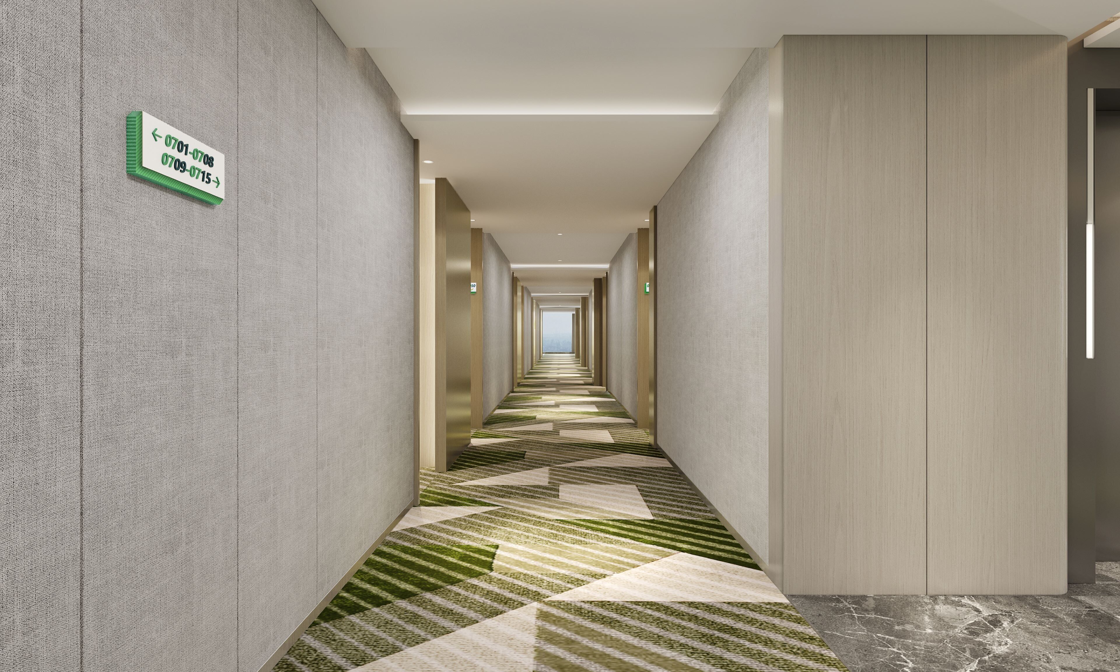 Un pasillo moderno de hotel con indicaciones, una alfombra estampada y vistas a la ciudad.