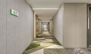 A modern hotel hallway with directional signs, a patterned carpet, and a view to the city. - Holiday Inn Yongkang (Jinhua)