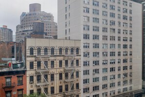 Ein mehrstöckiges Gebäude mit Feuerleiter, einer zylindrischen Struktur und einem modernen Hochhaus mit vielen Fenstern.